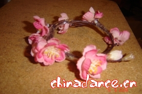 梳两个包头 把假花套上去就好了